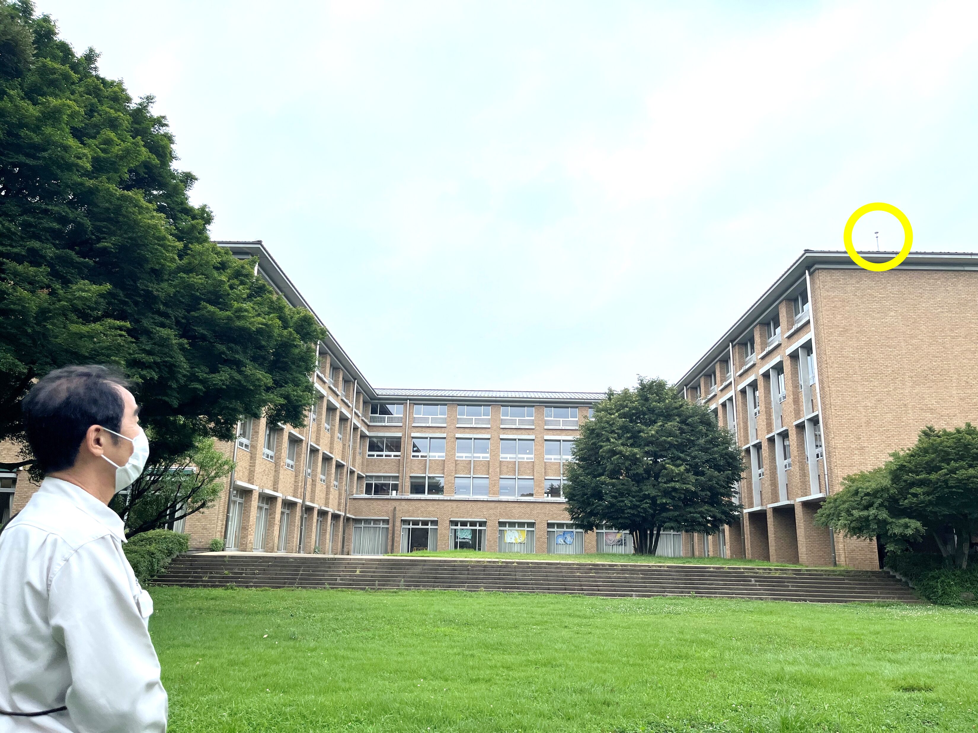 中学・高校棟の屋上に設置されたPDCE避雷球を見上げる石見様